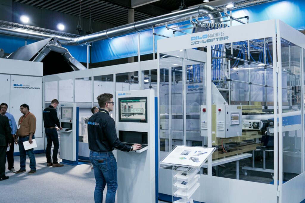 Hombre en una fábrica con una pantalla en tótem.